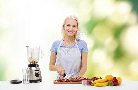 健康的饮食,烹饪,素食,饮食人们的微笑的轻女人与搅拌机切水果浆果的水果奶昔绿色的自然背景图片