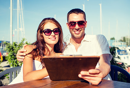 爱情,约会,人食物的微笑的夫妇戴着太阳镜,看着咖啡馆露台上的菜单图片