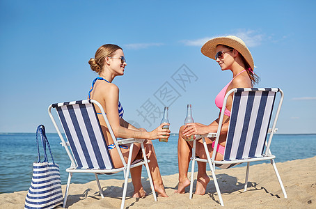 暑假,旅行人们的快乐的女人海滩的休息室里喝啤酒日光浴图片