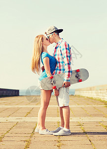 假期,爱友谊的微笑的夫妇与滑板亲吻户外图片