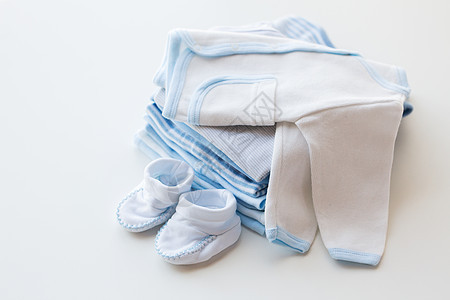 服装,婴儿,母亲象白色婴儿羊毛衫与靴子堆衣服为新生男孩图片