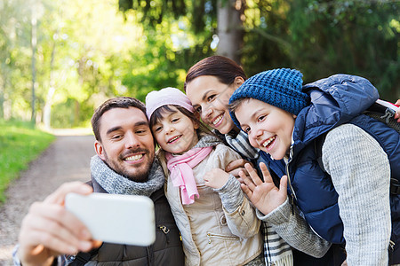 技术,旅游,徒步旅行人们的快乐的家庭与背包自拍智能手机徒步旅行图片