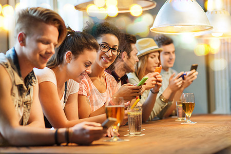 人,休闲,友谊,技术沟通的群快乐的微笑朋友酒吧酒吧用智能手机饮料图片