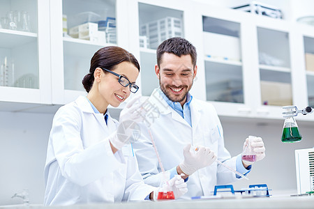 科学,化学,生物学,药学人的轻的科学家与吸管烧瓶制作测试研究临床实验室图片