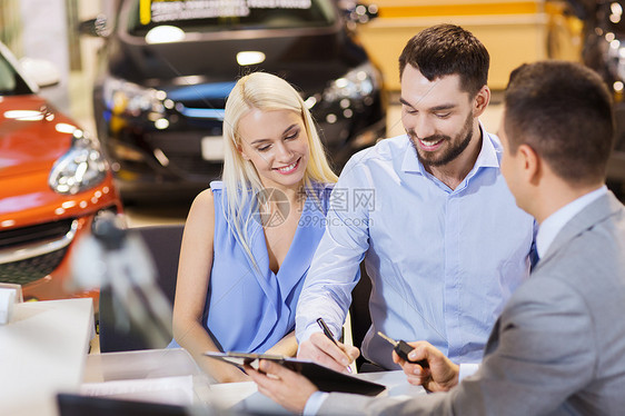 汽车业务,销售人的快乐夫妇与经销商购买汽车车展沙龙图片