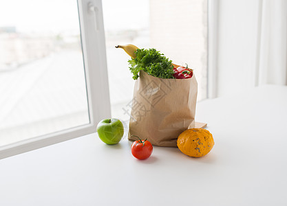 烹饪,饮食,素食健康饮食纸袋与新鲜成熟多汁的蔬菜,绿色水果厨房的桌子上图片