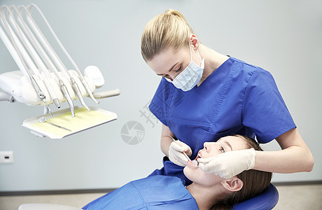 人,医学,口腔科保健快乐的女牙医用镜子探针检查病人女孩的牙齿牙科诊所办公室图片