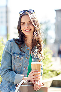 饮料人们的快乐的轻妇女十几岁的女孩喝咖啡,纸杯坐城市街道长凳上快乐的轻女人城市街道喝咖啡图片