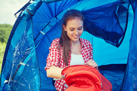 旅行,旅游,远足,野营人们的快乐的轻女人,背包坐帐篷里图片