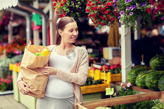 销售,购物,怀孕人们的快乐孕妇与纸袋充满食物街头市场图片