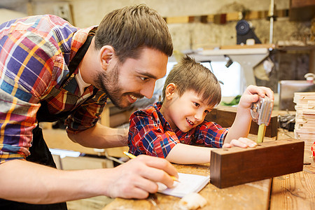 家庭,木工,木工人的父亲小儿子用尺子铅笔测量木板书写尺寸笔记本车间图片