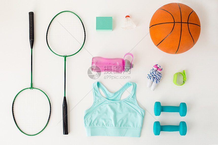 运动,健身,健康的生活方式物体羽毛球拍与篮球球,扬声器体育用品白色背景图片