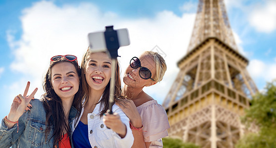 暑假,假期,旅行,技术人的群微笑的轻女巴黎背景的埃菲尔铁塔上用智能手机拍照图片