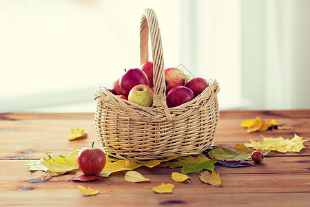 园艺,季节,秋天水果的柳条篮子与成熟的红色苹果树叶木桌上图片