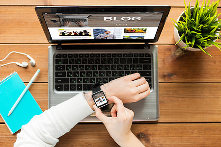 媒体,互联网,商业,人技术的妇女与智能手表笔记本电脑与博客网页屏幕上的木桌图片