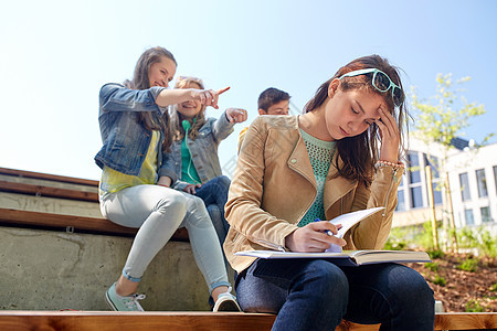 教育,欺凌,高中,社会关系人的快乐的学生女孩与书中的同学遭受嘲弄图片