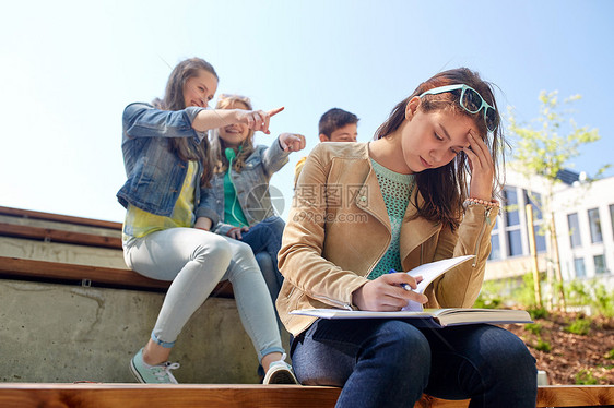 教育,欺凌,高中,社会关系人的快乐的学生女孩与书中的同学遭受嘲弄图片