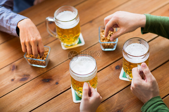 人,休闲饮料的男的手与啤酒杯花生酒吧酒吧图片