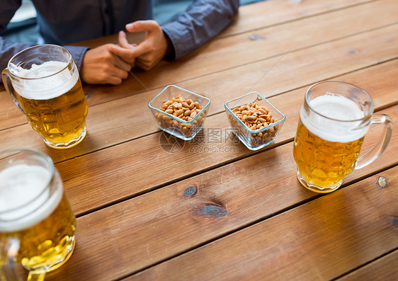 人,休闲饮料的男的手与啤酒杯花生酒吧酒吧图片