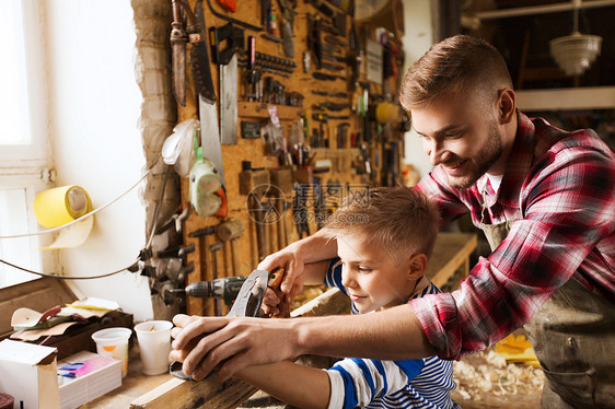 家庭木工木工人的父亲小儿子车间用木板飞机图片