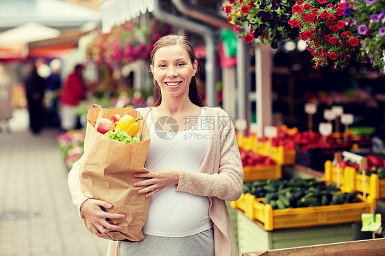 销售,购物,怀孕人们的快乐孕妇与纸袋充满食物街头市场图片