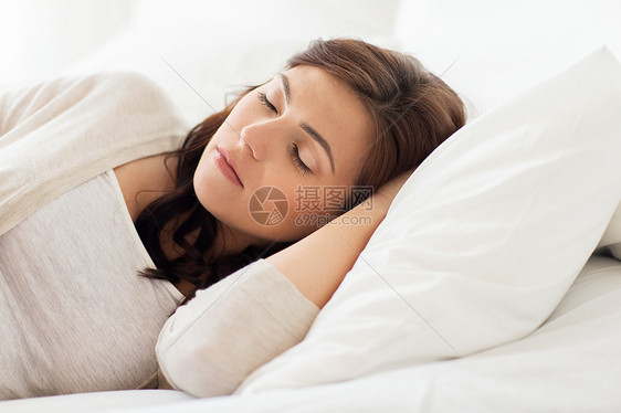 人,睡觉时间休息的轻的女人睡家里的床上图片