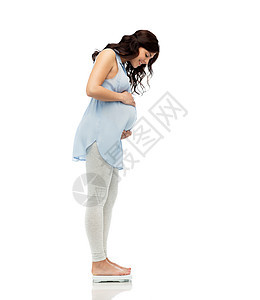 怀孕,保健人们的快乐孕妇测量体重的秤白色背景图片