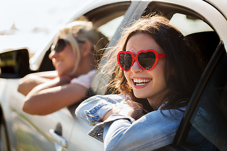 暑假,情人节,旅行,公路旅行人们的快乐的十几岁的女孩轻的女海边的汽车上的心形太阳镜图片