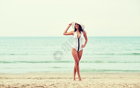 暑假,旅游,假期人的轻的女人穿着泳衣海滩上摆姿势图片