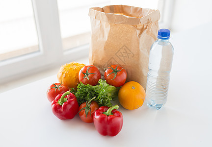 烹饪,饮食,素食健康饮食纸袋与新鲜成熟多汁的蔬菜水瓶厨房的桌子家里图片