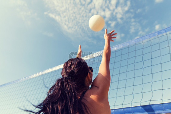 暑假,运动,休闲人的轻的女人海滩上打排球接球图片