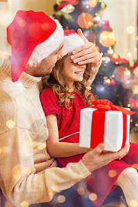 家庭,诞节,冬天,幸福人的微笑的父亲惊喜女儿用礼品盒遮住眼睛用手图片