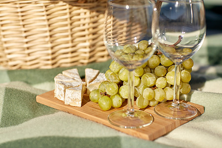 食物,假日,庆祝夏季野餐篮子与酒杯,葡萄奶酪木板上图片