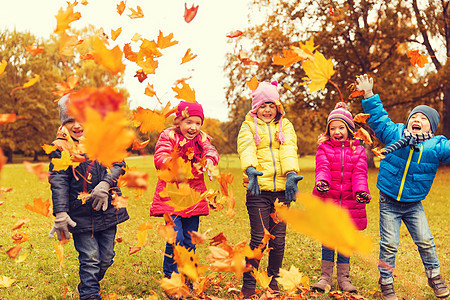 童休闲友谊人的群快乐的孩子玩秋天的枫叶,公园里玩得很开心图片
