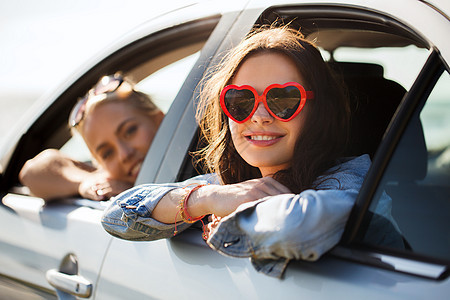 暑假,情人节,旅行,公路旅行人们的快乐的十几岁的女孩轻的女海边的汽车上的心形太阳镜图片