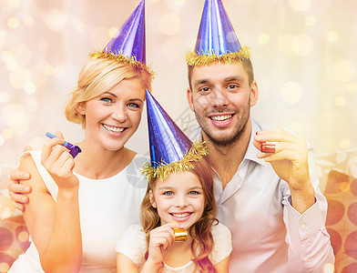 庆祝,家庭,节日生日的三个微笑的女人戴着蓝色的帽子,着爱的号角图片