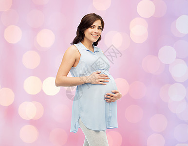 怀孕,母亲,人期望快乐的孕妇触摸她的大肚子玫瑰石英宁静假日灯光背景图片
