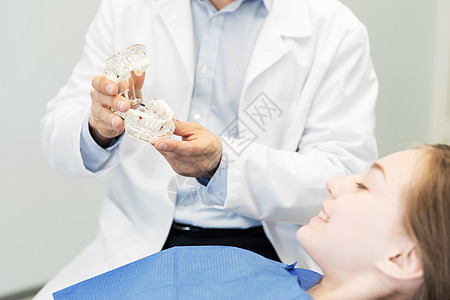 人,医学,口腔科保健快乐的男牙医下巴牙齿布局给病人女孩牙科诊所办公室背景图片