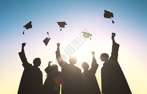 教育毕业人们的许多快乐的学生穿着长袍,空中投掷沙板图片
