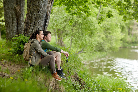 旅行,徒步旅行,背包旅行,旅游人们的微笑的夫妇背包休息河岸的自然河岸图片