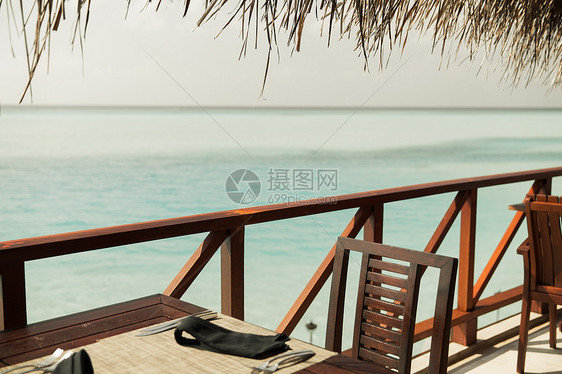 旅游,度假暑假的户外餐厅木制露台与桌子椅子的海洋背景图片
