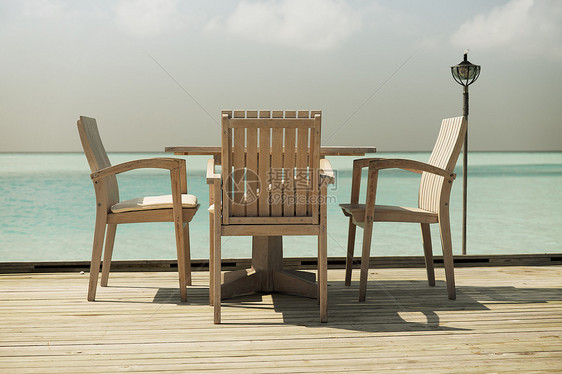 旅游,度假暑假的户外餐厅木制露台与桌子椅子的海洋背景图片