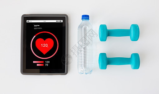 运动,健康的生活方式,健身,技术象的平板电脑与心率屏幕上的哑铃水瓶白色背景图片