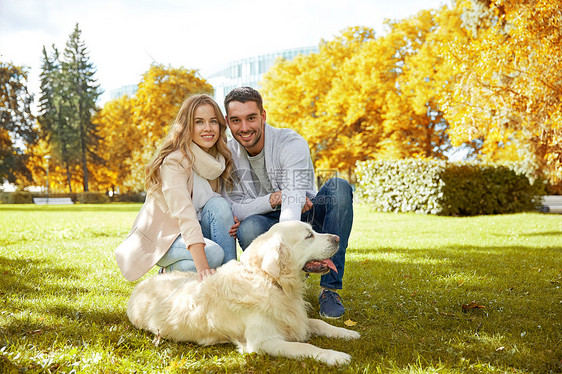 家庭,宠物,动物人的快乐的夫妇与拉布拉多猎犬秋天的城市公园散步图片