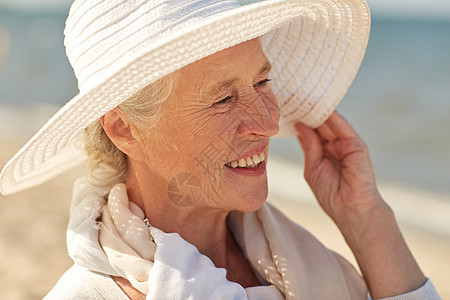 龄,休闲,旅游,旅游人的接近快乐的老妇女戴着太阳帽夏季海滩图片