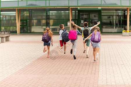 小学教育,友谊,童人的群快乐的小学生,背包户外跑步图片