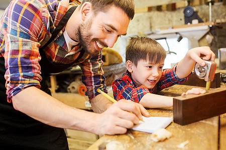 家庭,木工,木工人的父亲小儿子用尺子铅笔测量木板书写尺寸笔记本车间图片