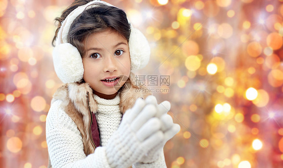 冬天,人们,诞节服装的快乐的小女孩戴着耳罩手套金色的节日灯光背景上图片