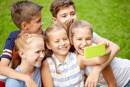 友谊,童,技术人的群快乐的孩子朋友夏季公园用智能手机自拍图片