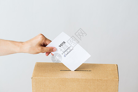 投票公民权利人民男手把两名候选人的投票放入选举的投票箱图片